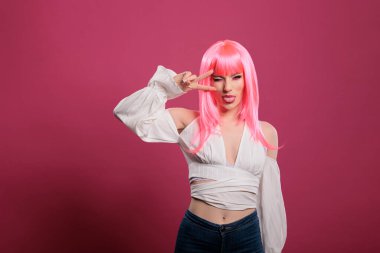 Kendine güveni olan birinin barış işareti yapması ve dilini dışarı çıkarması zafer jestini parmaklarıyla göstermesi. Barışçıl başarı sembolü tanıtmak ve stüdyo kamerasında oynaşmak..