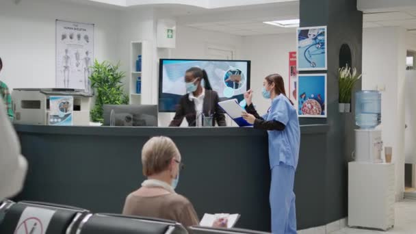 Asian Nurse African American Receptionist Talking Waiting Area Covid Epidemic — Vídeos de Stock