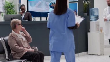 Sağlık hizmetleri kliniğinin resepsiyon lobisinde çeşitli tıbbi ekipler sağlık desteğinden bahsediyor. Bekleme odasındaki tedaviye yardımcı olması için raporların analiz edilmesi, check-up ziyareti.