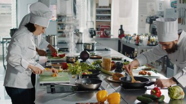Mutfak yemeği yapmak için havuç dilimleyen otantik bir aşçı restoran menüsü hazırlamak için organik malzemeler kullanıyor. Kadın aşçı, dilimlenmiş sebzeli gurme yemeği pişiriyor..