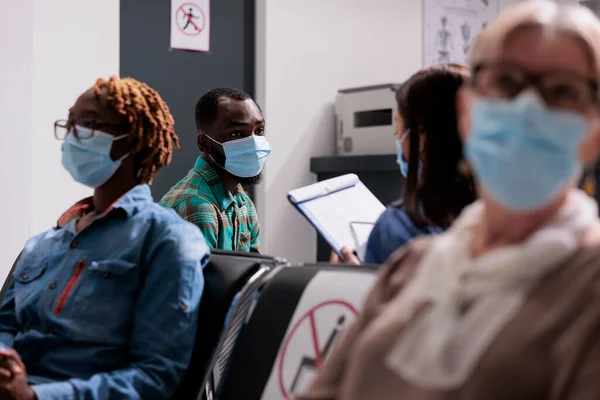 Yüzü Maskeli Afrikalı Bir Hasta Hemşireyle Konuşuyor Hastane Resepsiyonunun Lobisinde — Stok fotoğraf