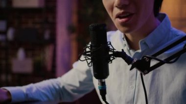 Podcast bölümünü kaydetmek için mikro-pone kullanan erkek blogcu, stüdyo istasyonunda profesyonel ekipmanlarla dinleyicilerle ve seyircilerle konuşuyor. Sosyal medya kanalı için içerik oluşturuluyor. Kapat..