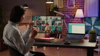 Ofis çalışanı masadaki iş arkadaşlarıyla konuşmak için bilgisayardaki video konferans görüşmesini kullanıyor. Sanal telekomünikasyon için uzaktan kumandalı konferans görüşmeleri. El kamerasıyla..