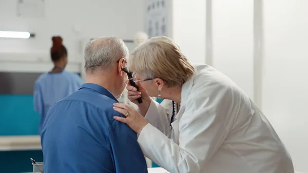 Otolaryngology specialist using otoscope to examine ear infection, helping patient with disease. Otology instrument to do ent consultation for audiology diagnosis in medical office.