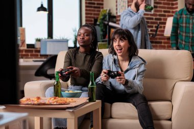 Kumanda panelinde oyun oynayan çeşitli kadınlar, arkadaşlarıyla parti yaparken eğleniyorlar. İnsanlar eğlence aktivitelerinden ve rekabetten zevk alıyor, bira içiyorlar..