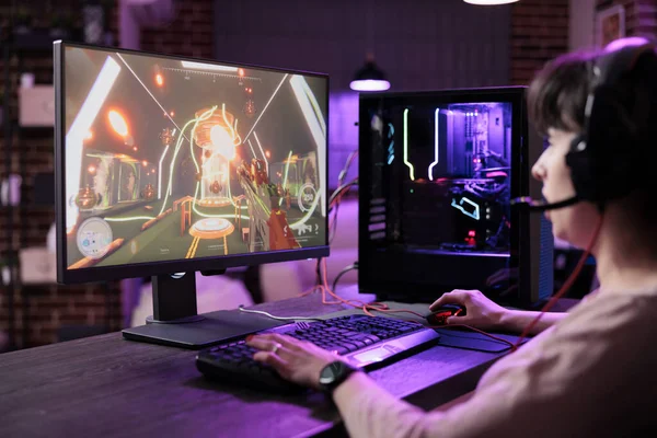 Young person streaming live video games championship on computer monitor, playing online game. Female player having fun with action rpg tournament gameplay on pc for entertainment.