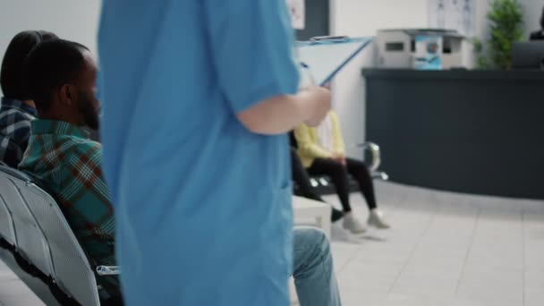 Portret Amerykańskiego Pacjenta Siedzącego Krześle Poczekalni Placówce Medycznej Czekającego Konsultację — Wideo stockowe