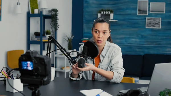 Famous internet tech enthusiast reviewing modern wireless mouse while presenting specifications to audience. Digital content creator doing unboxing video of electronic device in living room studio.