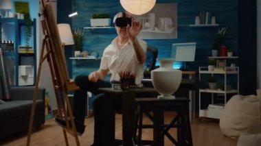 Emekli adam sanal gerçeklikle birlikte VR gözlüklerini kullanarak sanat ve zanaat atölyesi için şaheser tasarımı çiziyor. 3D fütüristik yenilikle etkileşimli gözlüklerle resim çizmek.