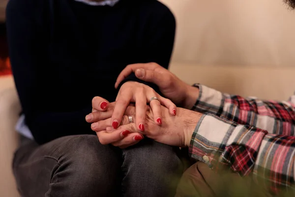Life partners holding hands at couple therapy session with counseling specialist, enjoying reconciliation after marriage issues. Solving relationship problems with professional help. Close up.