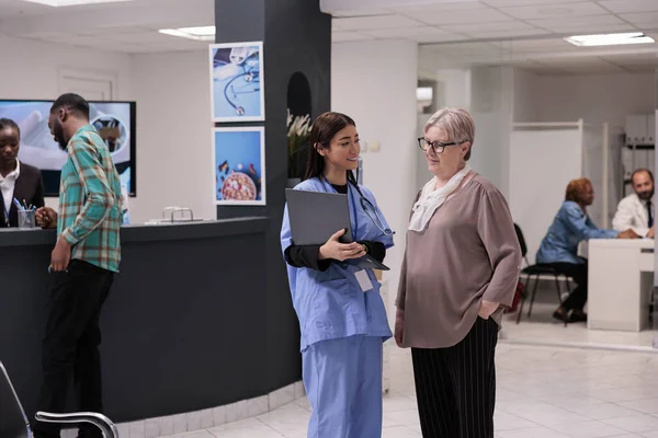 Medical Assistant Talking Disease Elderly Patient Hospital Reception Lobby Showing — Stock Photo, Image