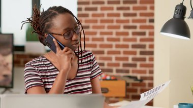 İş kadını akıllı telefondan insanlarla konuşuyor. Telekomünikasyon hattını kullanarak müdürle konuşuyor ve uzaktan çalışıyor. Telefonda sohbet, serbest ofis işi..