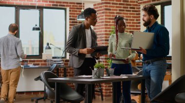 İş araştırmalarında çalışan çok ırklı bir grup iş arkadaşı dijital tablet ve kağıtlar hakkında çevrimiçi bilgi analiz ediyorlar. İnsanlar veri raporu ve analizi oluşturmak için beyin fırtınası yapıyorlar. Üçayak atışı.