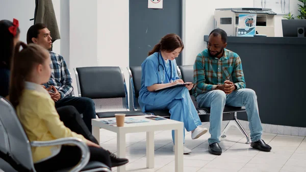 Paciente Afroamericano Haciendo Consulta Con Enfermera Médica Tomando Notas Vestíbulo — Foto de Stock