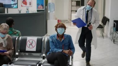 Female patient starting checkup consultation with doctor during covid 19 pandemic, doing medical examination to help with coronavirus prevention. Woman in waiting area at hospital reception.