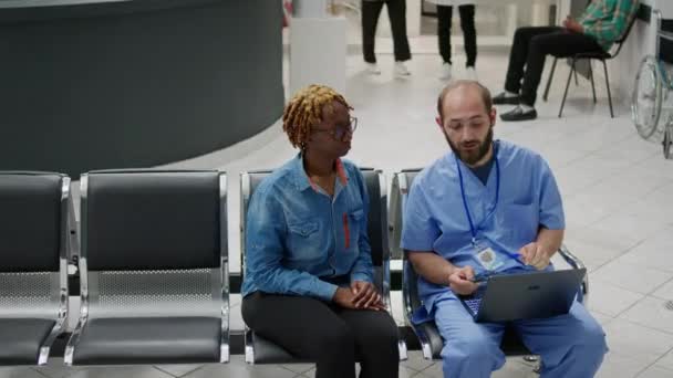 Male Nurse Showing Bones Radiography Results Patient Sitting Hospital Reception — Stock video