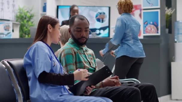 Diverse Menschen Sprechen Wartezimmer Der Rezeption Eines Krankenhauses Über Krankheitsdiagnosen — Stockvideo