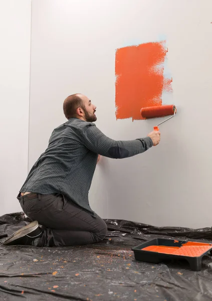 Άνδρας Ιδιοκτήτης Σπιτιού Ζωγραφική Τοίχο Πορτοκαλί Χρώμα Χρησιμοποιώντας Πινέλο Και — Φωτογραφία Αρχείου