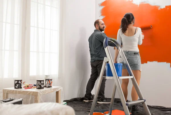 Man Woman Renovating Orange Paint Using Roller Brush Ladder Change — 图库照片