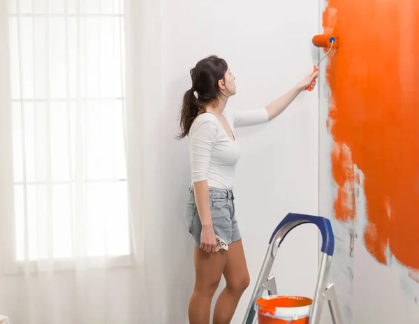 Vrouw Schilderen Muur Met Oranje Verf Kleur Met Behulp Van — Stockfoto
