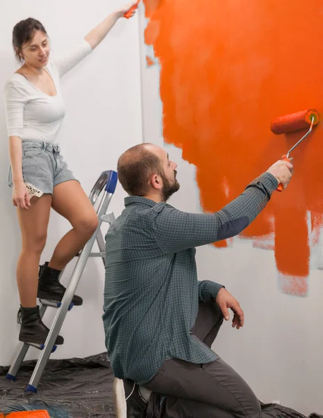 Familia Que Usa Pintura Naranja Para Renovar Las Paredes Del —  Fotos de Stock