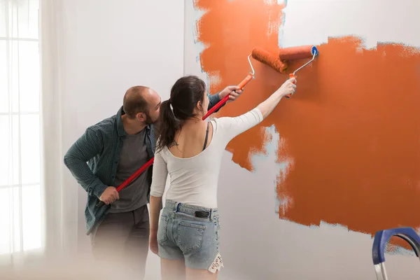 Família Usando Tinta Cor Laranja Nas Paredes Para Redecorar Sala — Fotografia de Stock