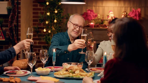 Cheerful Multicultural Family Members Toasting Champagne While Enjoying Christmas Dinner — Stockfoto