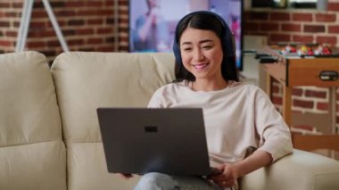 Cheerful woman working remotely while in virtual online videoconference with manager at home in living room. Smiling person talking with coworker on videocall digital meeting on laptop