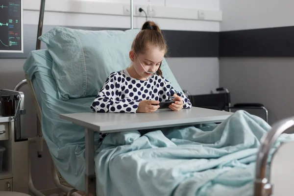 Sick Girl Treatment Resting Patient Bed While Watching Cartoons Smartphone — Fotografia de Stock
