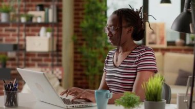 Freelancer working from home and having painful headache, feeling frustrated and stressed about remote work deadline. Woman suffering from migraine and being overworked at desk.