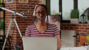Portrait of woman freelancer using laptop to do remote work at home office, working on startup with computer and online network. Employee working remotely, distant freelance work.