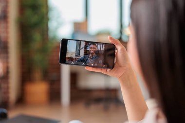 Otantik meşgul Asyalı kadın video görüşmesi yapıyor. İnternet üzerinden iletişim kuruyor. Mobil uygulamadan merhaba internet teknolojisi sallıyor.