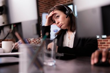 Genç bir kadın müşteri destek işinde yorgun hissediyor. Yardım masasında tele pazarlama merkezinde çalışıyor. Uzaktan iletişimde müşterilere yardım eden kadın resepsiyonist.