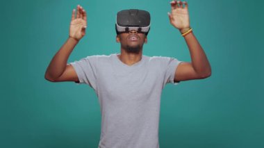Modern yetişkin kamerada video gözlük oyunuyla eğleniyor, 3 boyutlu görsel simülasyonla oynuyor. Milenyum adamı, sanal gerçeklik gözlüğü kullanıyor. Etkileşimli vizyonu ve geleceksel geliştirilmiş yazılımı var..