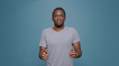 Stüdyoda hayal kırıklığına uğramış bir insan, negatif başarısızlık gösteriyor ve elleriyle yaptığı jestlere katılmıyor. Hoşnutsuz adam onaylamadığını, başarısız olduğunu ve reddedildiğini söylüyor..