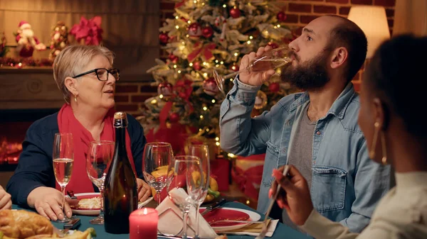 Selbstbewusster Mann Gespräch Mit Schwiegermutter Beim Weihnachtsessen Während Champagner Trinkt — Stockfoto