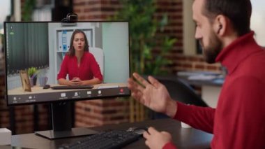 Erkek çalışan, kablosuz internet bağlantısı kullanarak uzaktan video konferans toplantısına katılıyor. Ofis çalışanı internetteki telekonferans videosundan kadınlarla konuşuyor, iletişim kuruyor. El kamerasıyla..