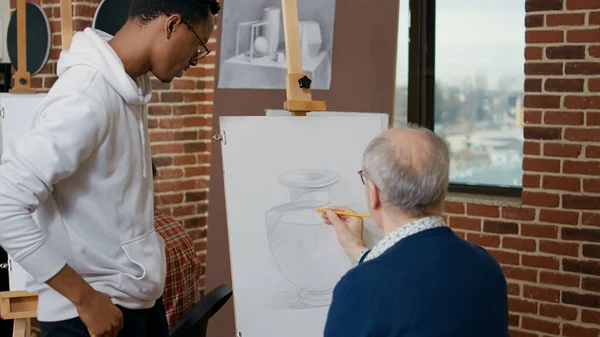 Jovem Artista Explicando Técnica Desenho Para Pessoa Mais Velha Usando — Fotografia de Stock