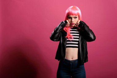 Portrait of attractive pretty woman wearing sexy leather jacket to advertise rocker fashion style with punk hairstyle. Carefree model feeling stylish and confident with elegant clothes in studio.