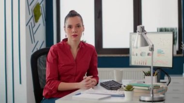 Proje yöneticisinin portresi ofis masasında oturmuş finansal tablolar ve satış istatistikleriyle iş büyümesi üzerinde çalışıyor. Pazarlama danışmanı bilgisayardaki ticaret şemalarını analiz ediyor..