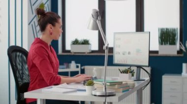 Company assistant analyzing business charts and graphs, looking at financial statistics on computer. Sales consultant using marketing data research to create executive report.