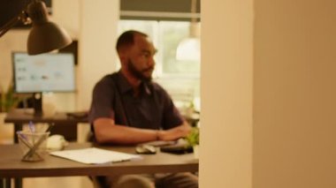 İş adamının portresi internette araştırma verilerini analiz ediyor, şirket raporuyla web sunumu planlıyor. Ofiste büyük pencereli kurumsal ağ belgeleri üzerinde çalışıyor.