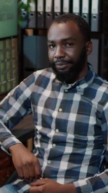 Dikey video: Afro-Amerikan yatırımcının portresi borsa satışlarını izliyor, gerçek zamanlı değişim parasını grafikler ve grafikler üzerinde analiz ediyor. Yatırım fonu hissesi yatırımı iş karını finanse etmek için.