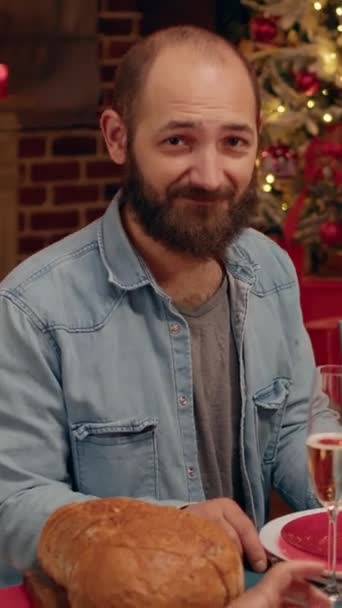 Вертикальне Відео Щасливий Бородатий Чоловік Сидить Різдвяним Обіднім Столом Близькими — стокове відео