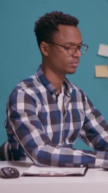 Dikey video: İyimser kişi aferin işareti, reklam onayı ve memnuniyeti gösteriyor. Dizüstü bilgisayarda çalışan serbest çalışan ve elleriyle ve başarısıyla iyi ve mükemmel bir jest yapan biri..