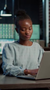 Vertical video: Female broker analyzing stock market exchange on laptop, planning forex investment with trade profit and sales numbers. Hedge fund statistics charts share to buy and sell money.