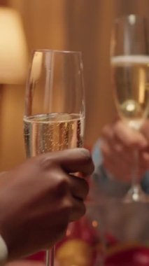 Vertical video: Joyful people gathered at Christmas dinner table to celebrate winter holiday in living room. Happy smiling family members celebrating traditional winter holiday inside Xmas decorated