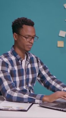 Dikey video: Ofis çalışanı saygı ve vatanseverlik göstermek için askeri selam veriyor, ordu askerinin diz üstü bilgisayar önünde yaptığı onur jestini tanıtıyor. Kıdemli Çavuşun imzasıyla selamlama