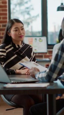 Dikey video: İş deneyimi ve iş teklifi hakkında iş görüşmeleri yapan bir erkek oyuncu. Erkek ve kadın İK 'nın işe alınması hakkında konuşmak için toplanıyor, işe alınacak bilgileri analiz ediyorlar..