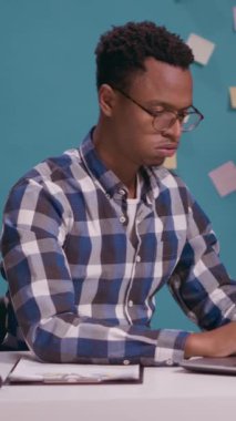 Dikey video: Umutsuz adam dizüstü bilgisayara bağırıyor iş krizi yaşıyor ve hayal kırıklığına uğruyor. Ofis masasındaki bilgisayara bağırıp bağıran kızgın bir çalışan. Saldırgan.